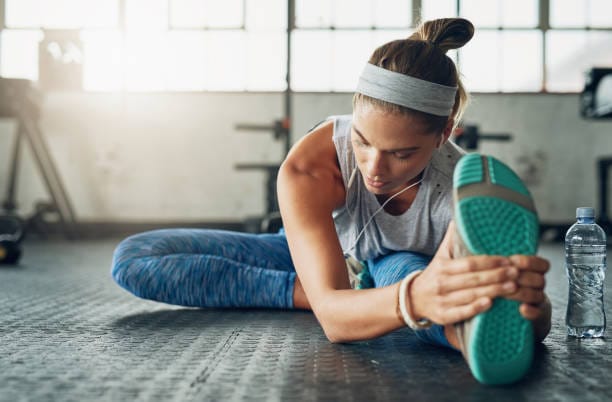 Woman stretching her leg in a fitness studio.