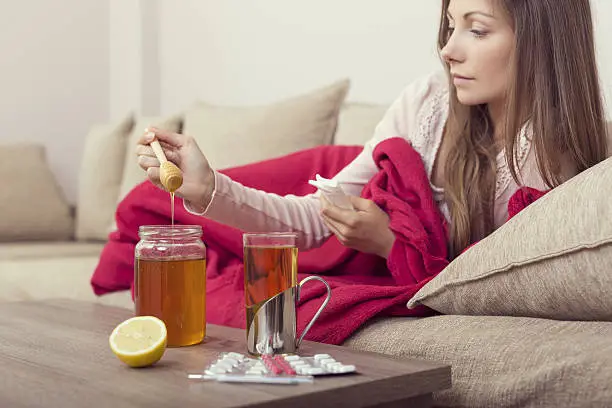  A woman using honey, known for its natural healing properties.